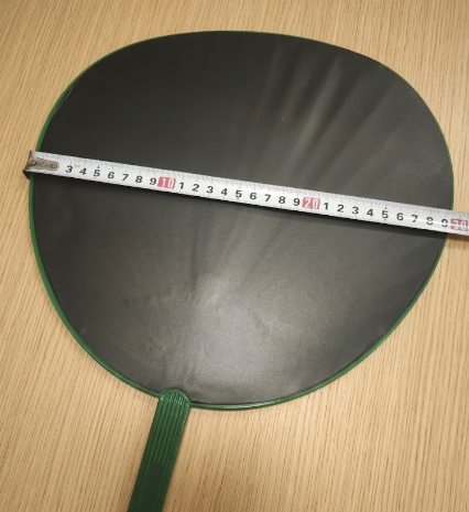キャンドゥ応援うちわの横幅をメジャーで約29.5cmと測っている写真